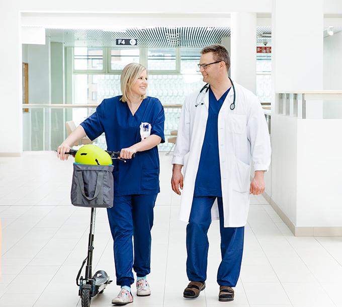 A doctor and a nurse in a hospital corridor.